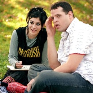 Screenshot from Mean Girls, with Janis and Damian sitting together on the grass