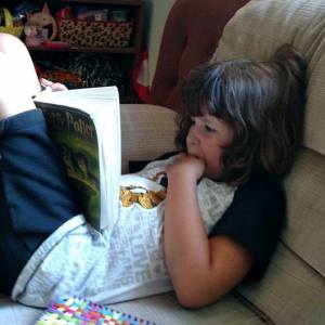 Photo of Sophie Katcher, age 8, reading that scene in Harry Potter where Dumbledore dies