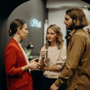 Three white people, two women and one man, talking to each other