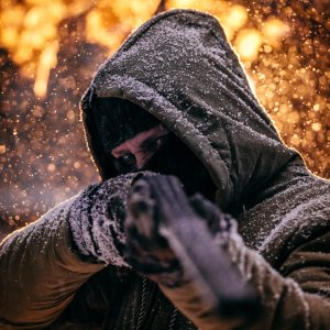 Masked man pointing shotgun at the viewer.