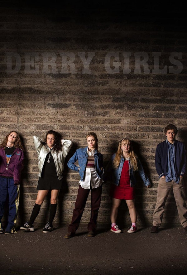 Derry Girls Cover: 4 girls and a boy lean against a brick wall
