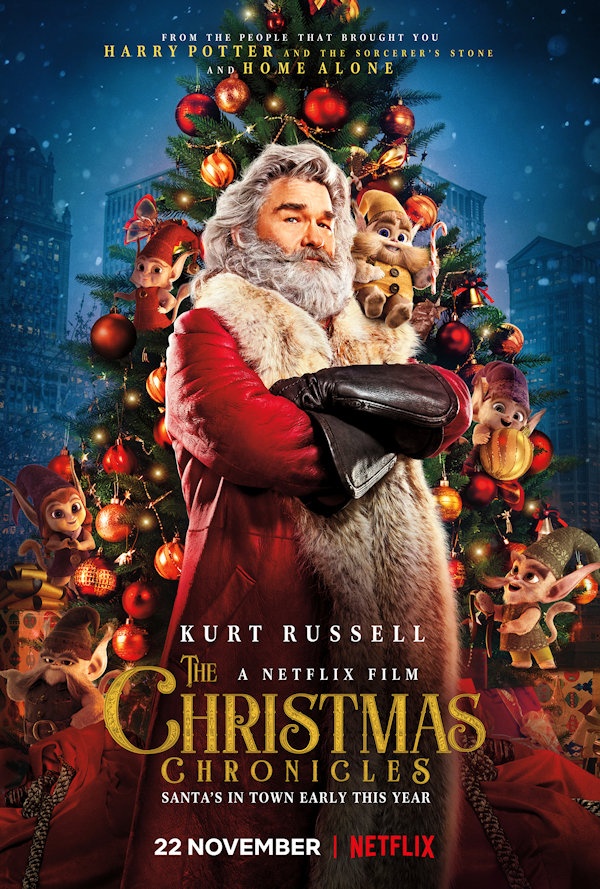The Christmas Chronicles Cover: Santa stands in front of a large christmas tree with cartoon elves hidden about