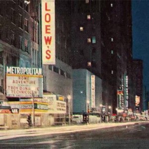 Downtown street in Houston from the 1960s, with lit-up signs for Loew's and the Metropolitan