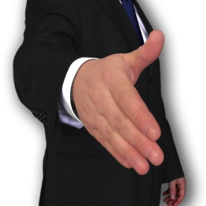 Man in a suit, extending hand to shake