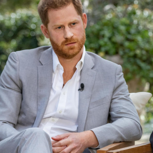 Prince Harry looking serious and dapper in a gray suit