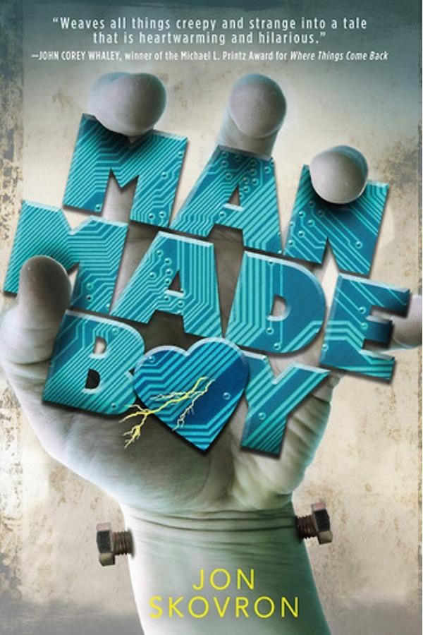 Cover of Man Made Boy. A hand, with Frankenstein's Monster neck bolts in the wrist, clutches the title.