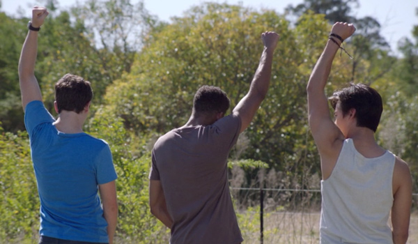 Ben, Ollie, and Christian walking down the road and pumping their fists