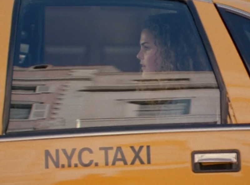Felicity, looking straight ahead while sitting in the back of a taxi