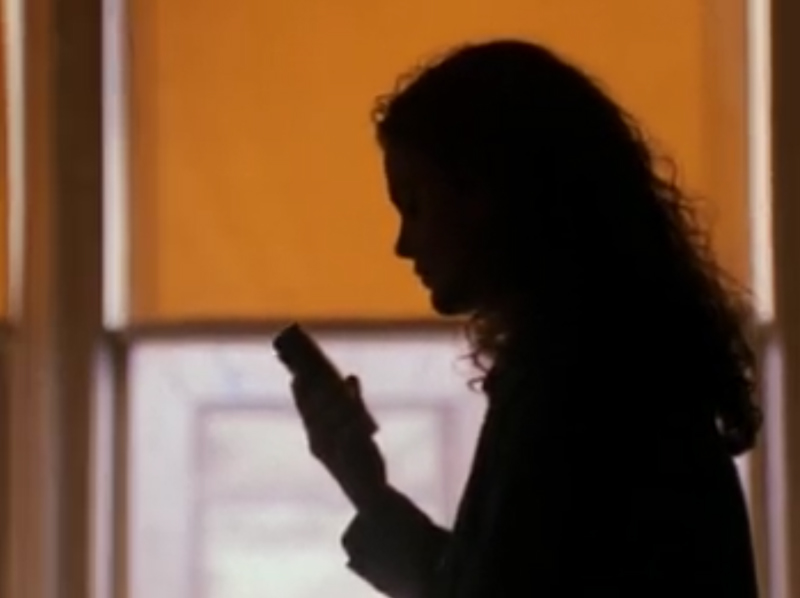 Felicity, in silhouette, talking to Sally on her tape recorder