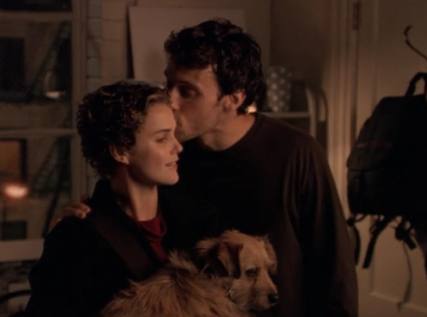 David kissing Felicity's forehead while she's holding a medium-sized dog
