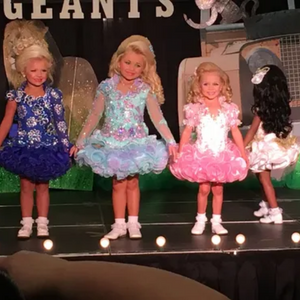 Three little girls onstage at a Toddlers and Tiaras beauty pageant
