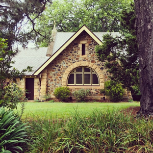 Stone cottage surrounded by grass and trees