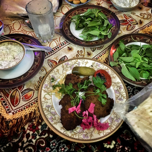 Meat and veggies on plates laid out on a patterned cloth