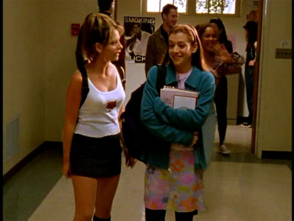 Buffy and Willow walk down the hall in bad 90's outfits