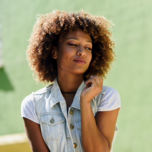 A Black woman in a button down shirt with a fro