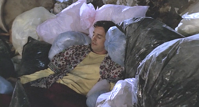 Xander lies in a pile of garbage bags