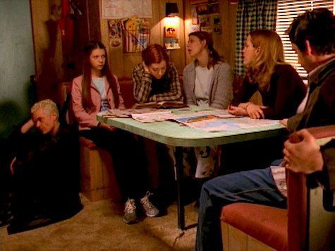 The Scoobies sitting around a table in an RV