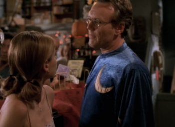 Giles is wearing a wizard robe with a crescent moon on it