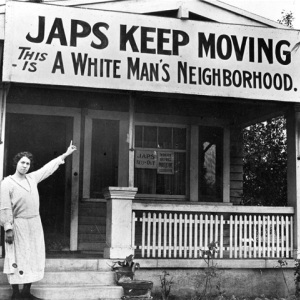 Famous black and white photo of a woman pointing to a sign declaring this to be a white man's neighborhood