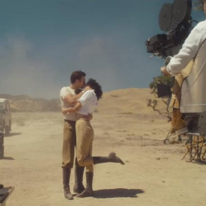 Screenshot from Wildest Dreams, with two actors kissing in the desert while the camera rolls