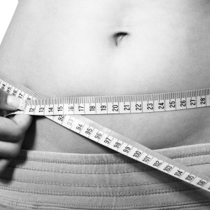 A woman's belly with a tape measure around it