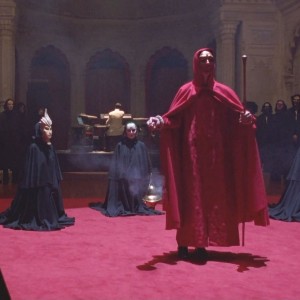 Screenshot from Eyes Wide Shut, with masked figures in cloaks performing a secret ritual