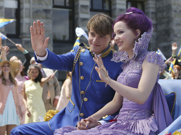 Ben and Mal, wearing royal finery and waving to onlookers as they ride in a coach