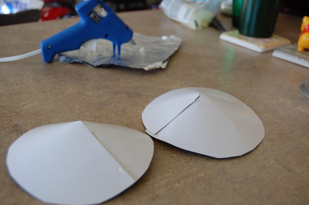Two cardboard circles with the missing pie piece closed over and glued