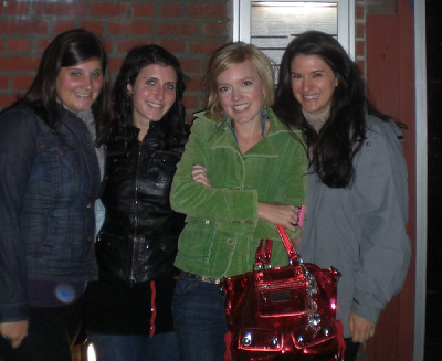 Katie, Leila, Sarah, and Rebecca standing together against a brick wall