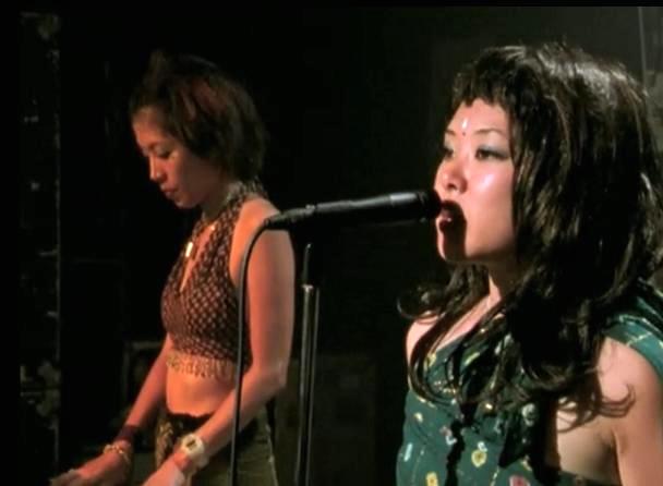 Two Japanese women dressed in an alterna style, singing and playing music