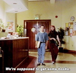Giles, Xander, and Cordelia are standing in the library when two students walk in