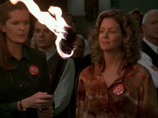 Joyce, wearing a MOO button and holding a flaming torch