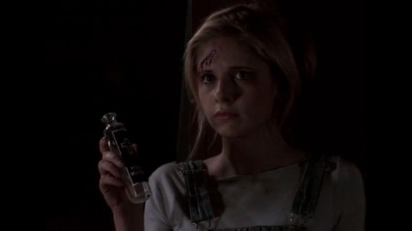 Buffy, with a bloody scratch on her forehead, holding a glass vial