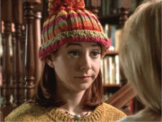 Willow wearing a red, orange, and yellow striped knit hat with a pom-pom at the top