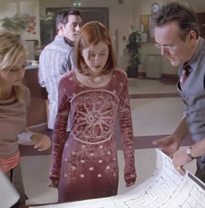 Willow, wearing a long sleeve wine-colored velvet dress with a celestial design on it