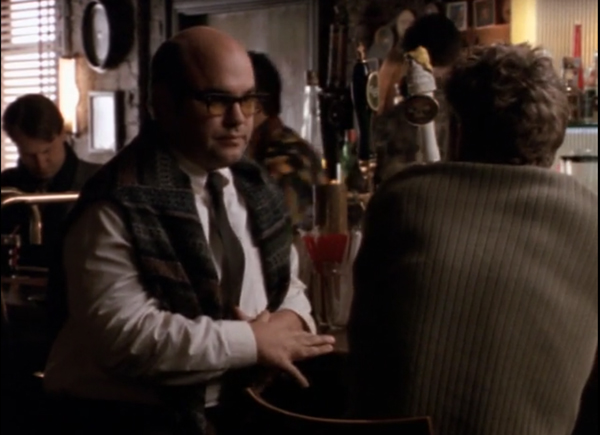 Javier, wearing a tie and sweater vest, sitting at a table with Ben