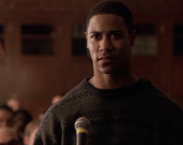 Actor Brian White, a handsome young Black man, playing a student at the podium