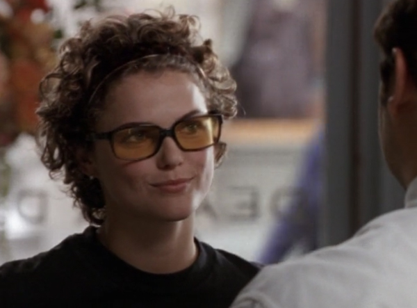 Felicity, rocking Javier's glasses, which have black rectangular frames and slightly orange lenses