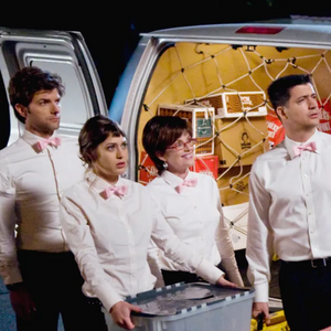 The cast of Party Down standing by a catering van in their white shirts and bow ties