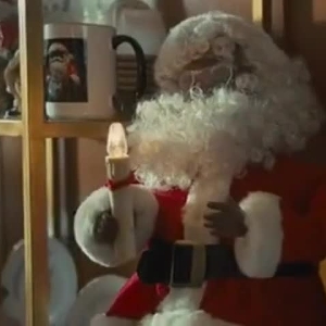 Screenshot from Paper Towns of a Black Santa doll on a shelf