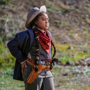 Quita Brunson in Miracle Workers: Oregon Trail. She's dressed as a gunslinger