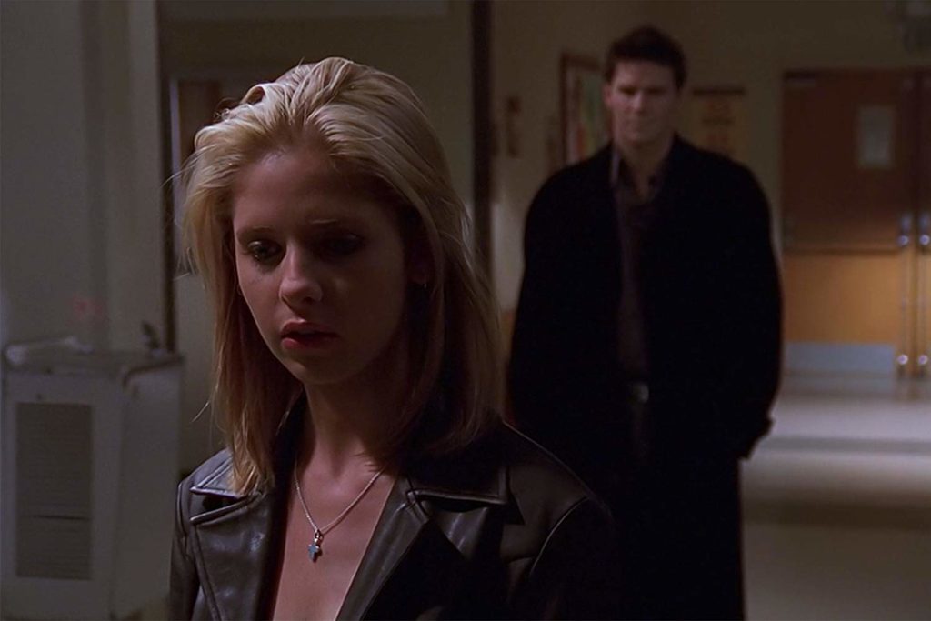 Buffy walking down the hall, with Angelus stalking behind her