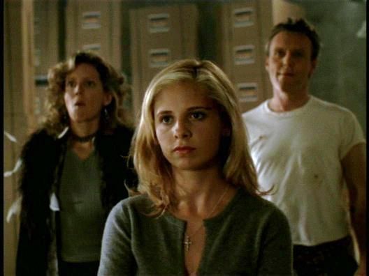 And irritable looking Buffy with Joyce in a fur jacket and Giles in a white tee behind her