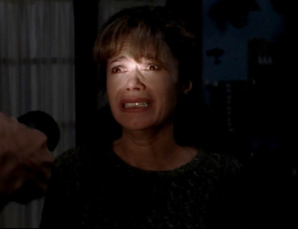 Gail stands in a darkened room, looking terrified