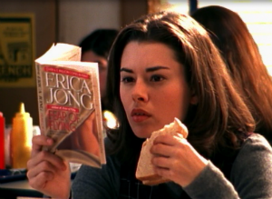 Megahn Perry as Mary Beth, reading a book and eating a sandwich at lunch