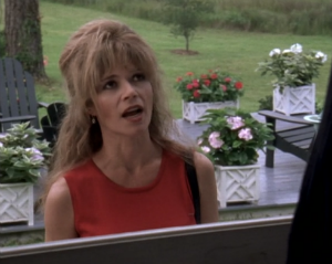 Gail stands in the yard with huge, frizzy hair and giant bangs