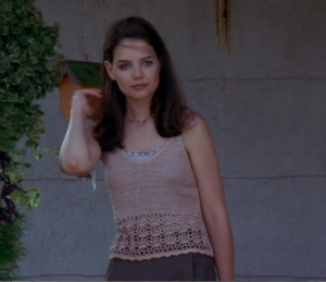 Joey wears a pink crocheted tank top and brown skirt