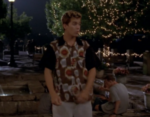 Pacey wears a baggie, short-sleeved button down printed with, like, fireballs
