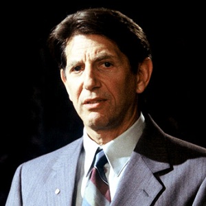 Peter Coyote, wearing a suit and tie, as Jamie's dad