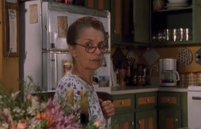 Grams sits at the table, staring sternly over her shoulder and over a pair of reading glasses like a righteous librarian.